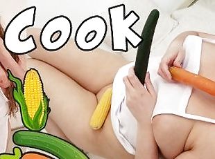 Chubby blonde cook inserting cucumber, carrot and corn