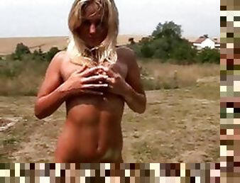 Busty bikini babe oils up her body outdoors