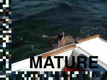 Nudist mature couple having sex on the boat