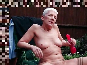 Granny masturbates outdoors with a vibrator