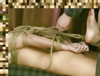 Cute girl is put into complicated rope bondage