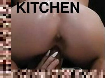 Fucking and sucking a dildo in the kitchen at night