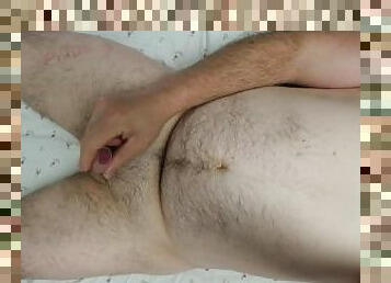 Hairy obese man recording him self while masturbating's and cumming on his groin while laying on bed