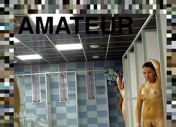 Naked girl with beautiful tan lines takes a shower.