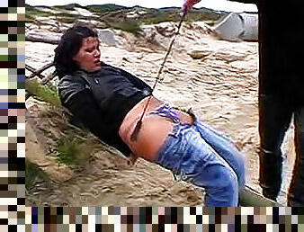 Nude brunette in blue jeans is having unbelievable pain outdoors