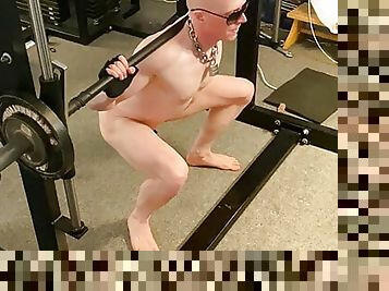 Locked plugged naked slave doing a workout