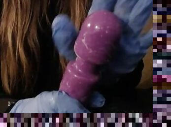 Soaping up and cleaning a dildo with latex gloves