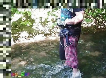 German guy stands in a creek, pisses and jerks off his hard cock