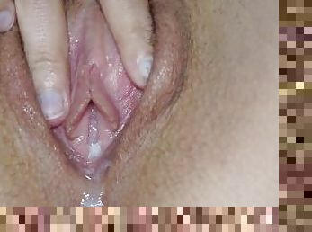 Spreading of not shaved creamy pussy close up