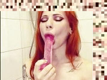 The redheaded pussy sucks her pink dildo and enjoys