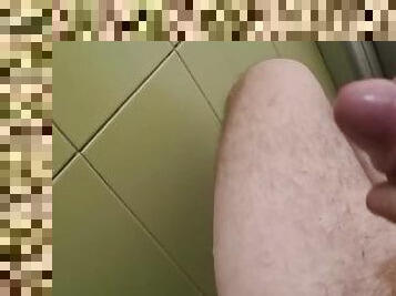 a guy with a big dick jerks off in a public toilet and cums on the wall